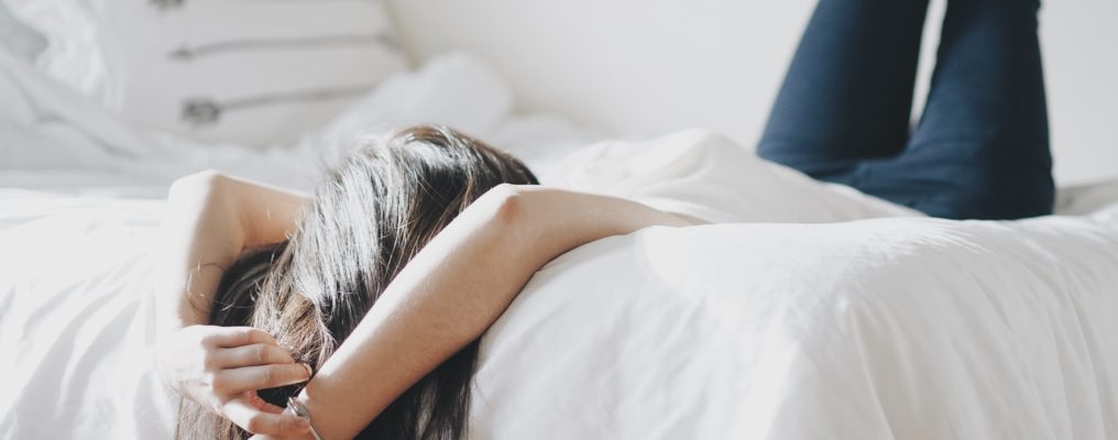 Kobieta odpoczywa na łóżku przy świetle słońca